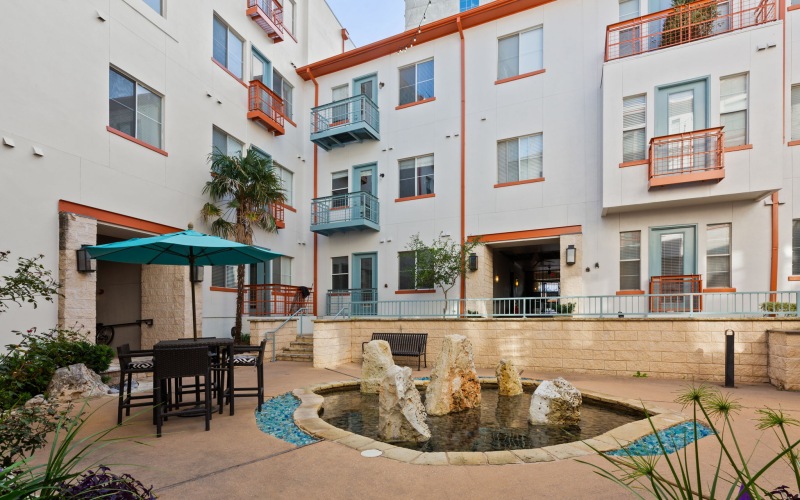 a courtyard with a fountain and buildings