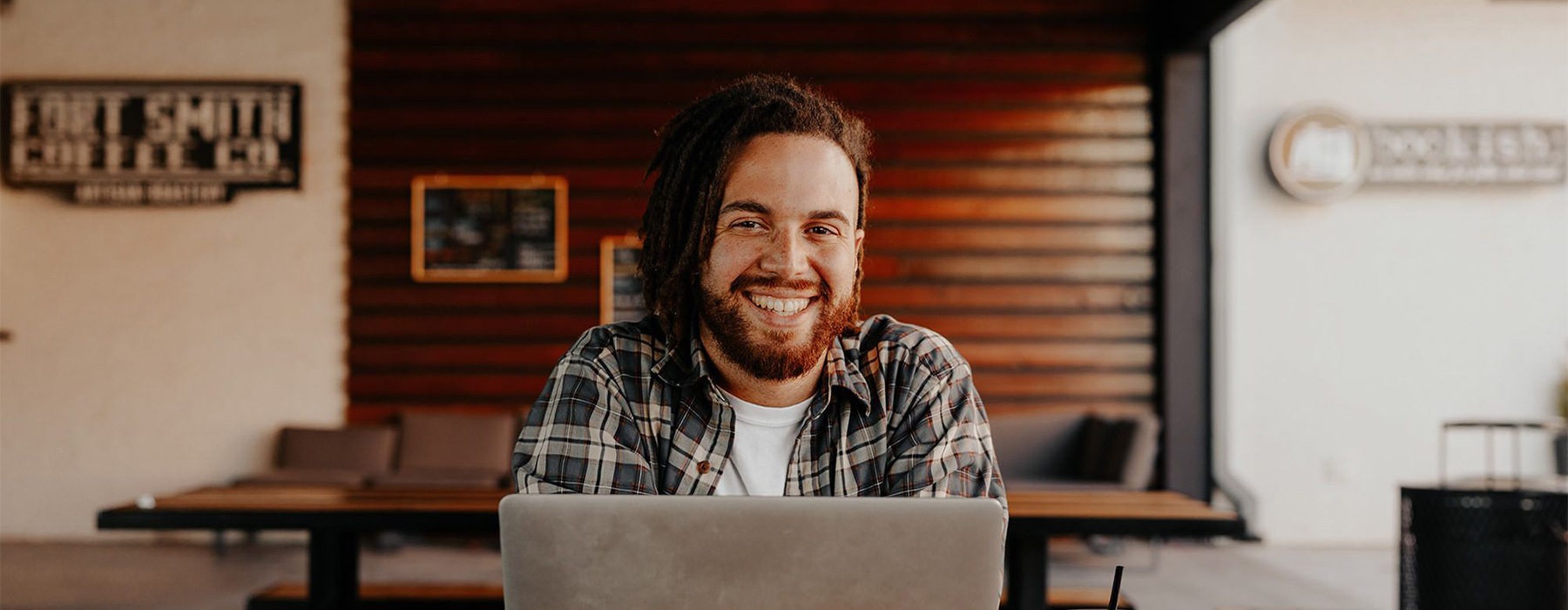 a man smiling in front of a laptop
